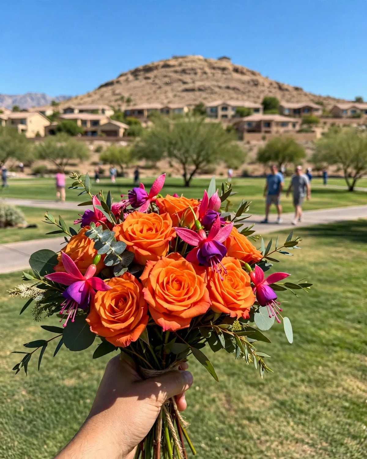 Hand-held bouquet of orange roses and magenta blooms at Exploration Peak Park in Mountain's Edge, Enterprise, Las Vegas