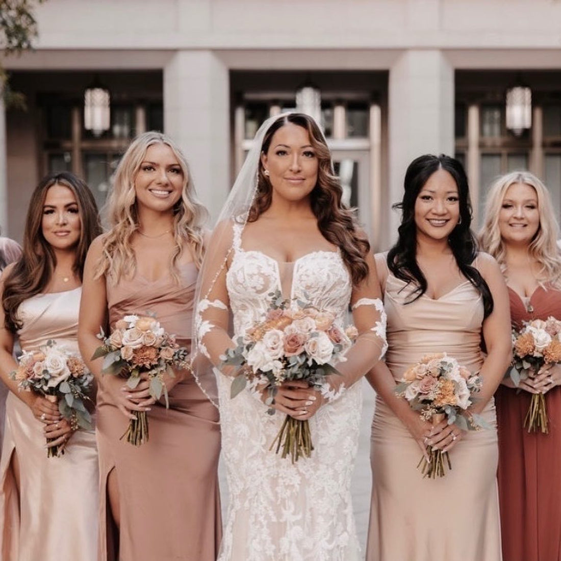 Bride with four bridesmaids in blush dresses holding blush and peach wedding bouquets in Las Vegas