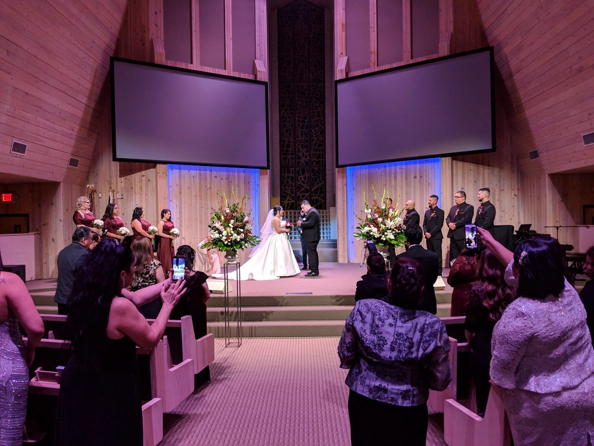 Las Vegas church wedding ceremony with large red and white altar flower arrangements flanking the bride and groom